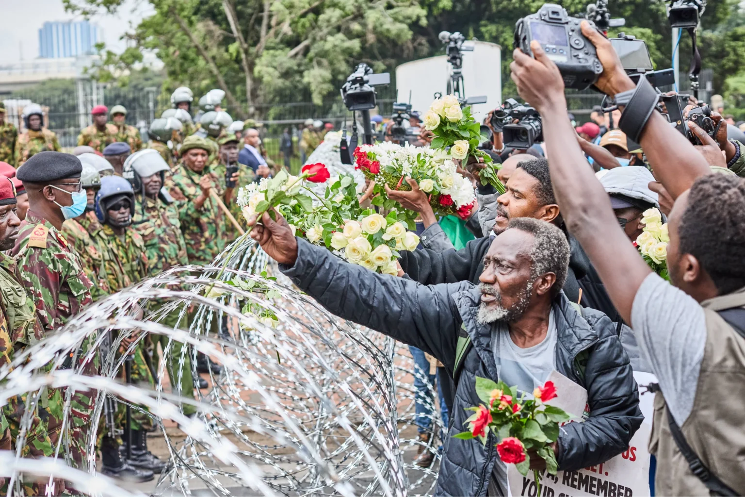 Families of June 25 protest victims lay flowers outside barricaded Parliament